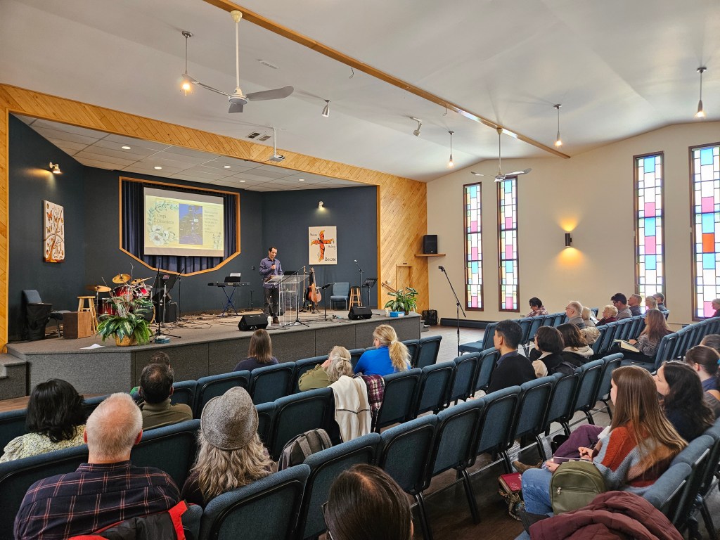A picture of the pastor giving a sermon inside the church.